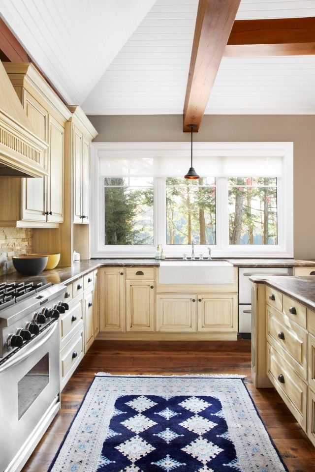 Rustic kitchen with navy blue area rug near stove 